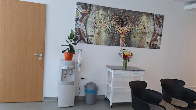 Várótér székekkel, vízadagolóval és faliképpel